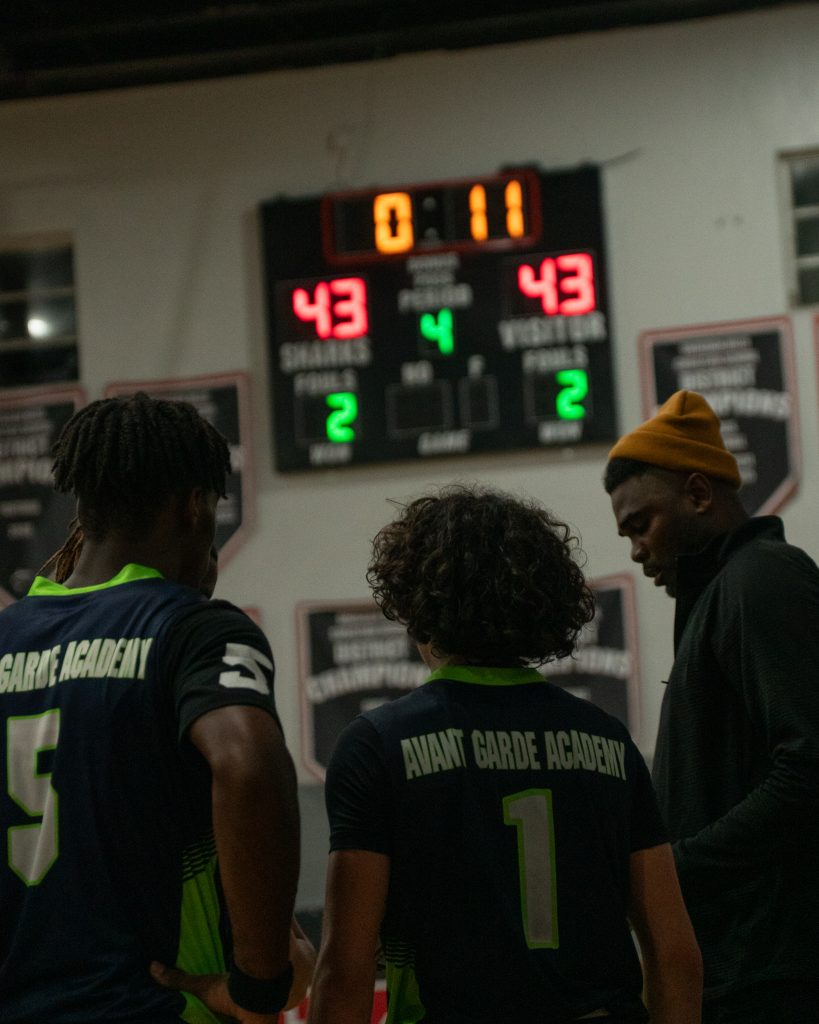 Player 5, 1, and their coach are thinking of the next move as they have 11 seconds left in their basketball game.